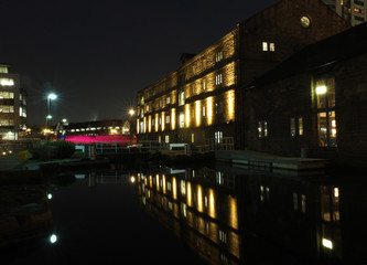 Fototapeta na wymiar number one lock on the leeds canal at night near granary wharf with victoria bridge and illuminated buildings reflected in the water
