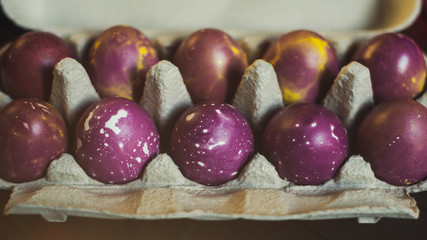 dyed easter eggs in box at black wooden background