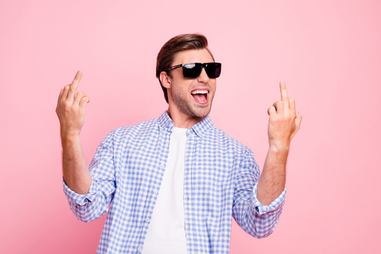 Close up photo of beautiful amazing brunet he him his handsome with fuck you haters symbol good luck bitches wearing specs casual checkered plaid shirt outfit isolated on rose background