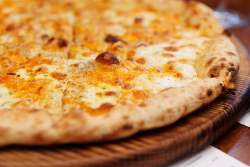 Four cheeses pizza on serving board