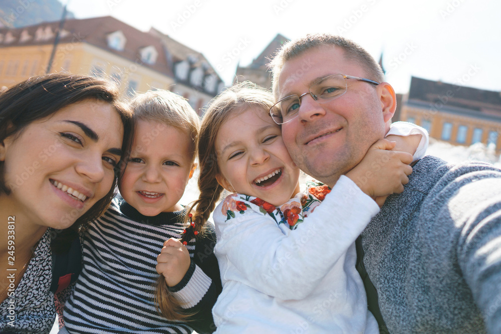 Poster laughing family making selfie in city