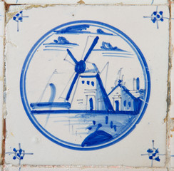 Delft blue and white tile with the painting of a windmill