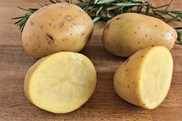 patate tagliate e rosmarino su tagliere di legno