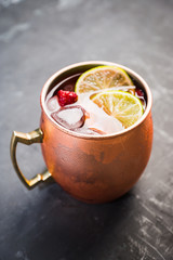 Sweet moscow mule with lime and raspberry in copper mug on the rustic background. Selective focus. Shallow depth of field. 