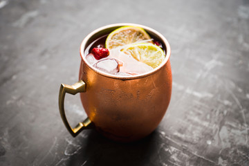 Sweet moscow mule with lime and raspberry in copper mug on the rustic background. Selective focus. Shallow depth of field. 