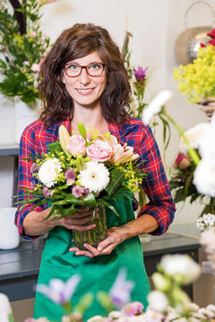 Freundlich l&auml;chelnde Floristin mit frisch gebundenem Blumenstrau&szlig;