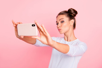 Portrait of her she nice cute attractive winsome lovely sweet cheerful cheery positive girl holding cell in hands making selfie isolated over pastel pink background