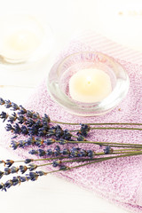 Obraz na płótnie Canvas Dried lavender flowers herb with tealight candle with towel on table, spa setting. Vertical