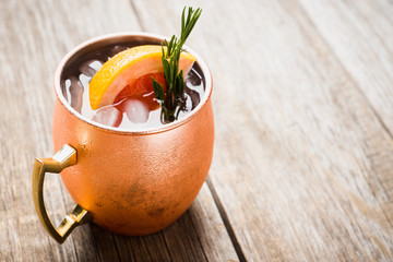 Grapefruit moscow mule in copper mug on the rustic background. Selective focus. Shallow depth of field. 