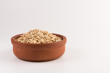 Dry rolled oatmeal in bowl isolated on white background.