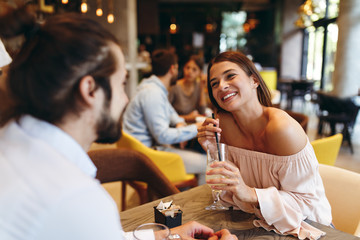 Young happy couple at a date in a coffee shop - obrazy, fototapety, plakaty