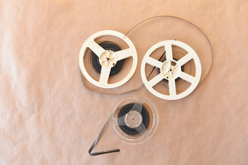 Old vintage cinematic reels of white color and transparent with a video film lie on the background of the Kraft surface. Top view.