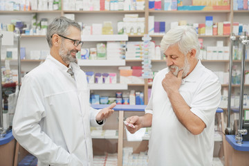Fototapeta na wymiar Pensioner and pharmacist consulting in drugstore.