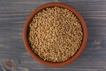 Yellow lentil in a bowl on wooden background