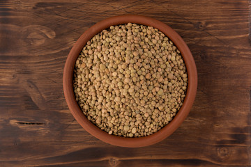Yellow lentil in a bowl on wooden background