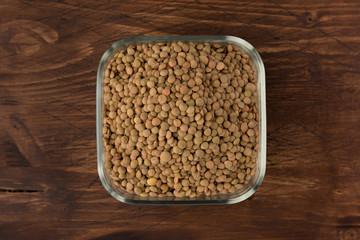Yellow lentil in a bowl on wooden background