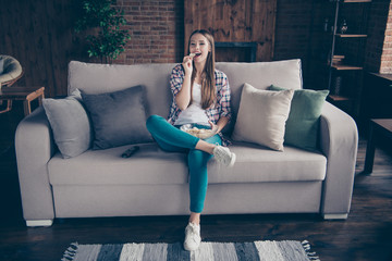Obraz premium Full body length size photo portrait of cheerful positive interested charming she her teenager teen girl having recreation on divan tasting fast food from plate in hands