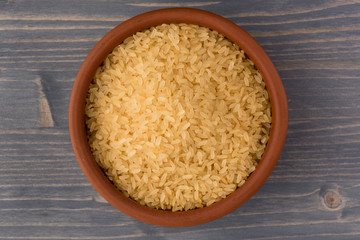 white rice in bowl on wooden table background