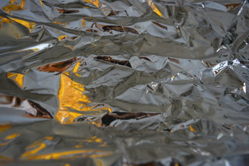 Stylish metallic, gray, reflective melik background. Festive background with brightness and light effects and gloss on silver crumpled film.