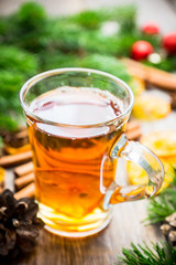 Hot tea in glass cup with atmospheric winter decorations. Selective focus. Shallow depth of field.
