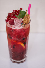 Tasty cold fresh drink lemonade with raspberry, mint, ice and lime in glass 