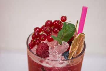 Tasty cold fresh drink lemonade with raspberry, mint, ice and lime in glass 