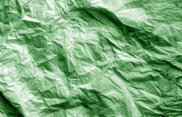 Crumpled sheet of paper in green color.