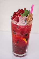 Tasty cold fresh drink lemonade with raspberry, mint, ice and lime in glass 