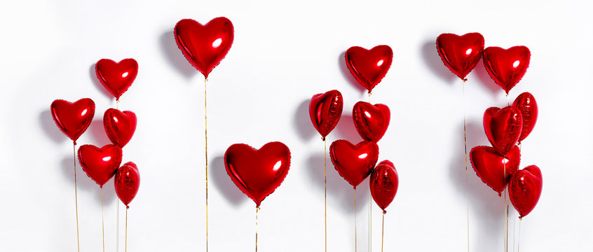 Set of Air Balloons. Bunch of red color heart shaped foil balloons isolated on white background. Love. Holiday celebration. Valentine's Day party decoration. Metallic red  Heart air balloons