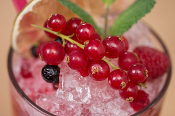 Tasty cold fresh drink lemonade with raspberry, mint, ice and lime in glass 