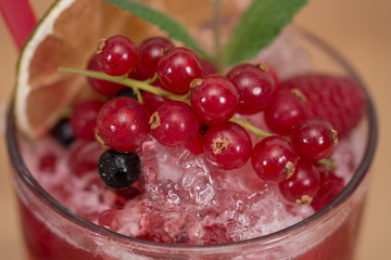 Tasty cold fresh drink lemonade with raspberry, mint, ice and lime in glass 