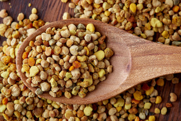 Close up of bee pollen grains in wooden spoon