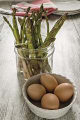 asparagi crudi sopra tavolo rustico con uova