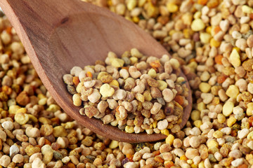Close up of bee pollen grains in wooden spoon
