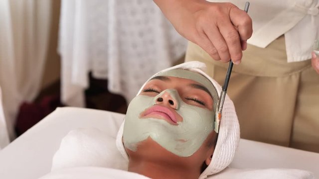 Beautiful young asian woman with facial mask at beauty spa salon. Beauty Treatments, health. 4k video Slow Motion