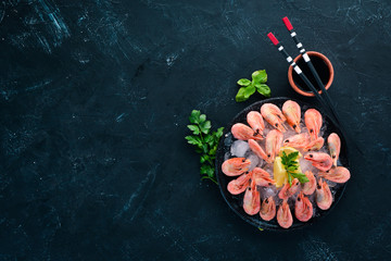 Shrimp with ice and lemon. On the old background. Top view. Free copy space.