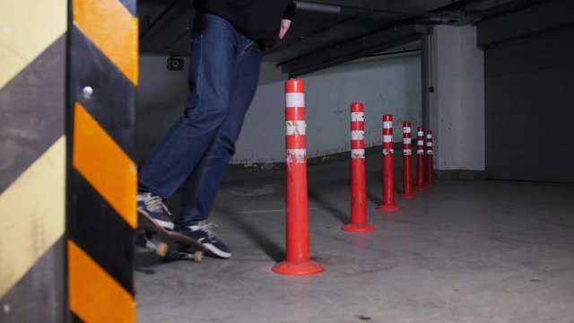 A young man skateboarding on his board with military colors in the parking lot. Skating around obstacles