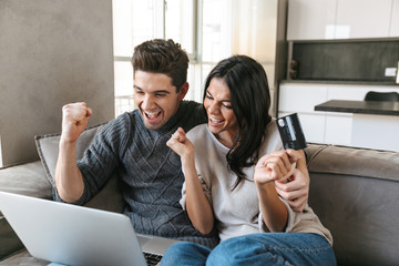 Happy young couple sitting on a couch at home