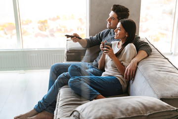 Happy young couple sitting on a couch at home