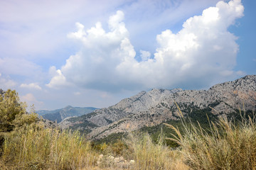 Sky with majestic clouds over mountains on summer day.