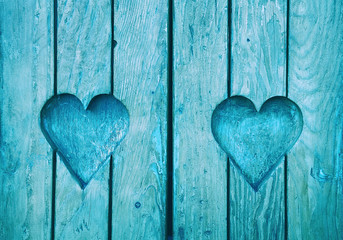 Two heart shapes carved in vintage wooden planks