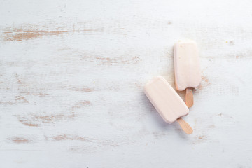 Ice-cream with white chocolate on a white background. Top view. Free copy space.