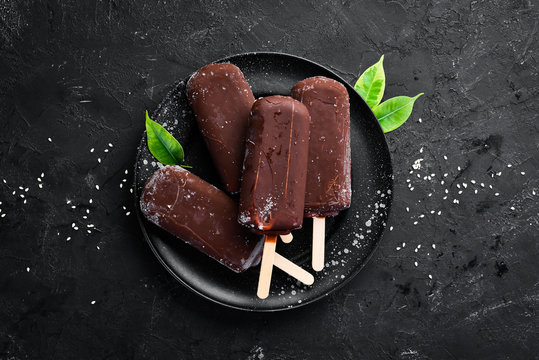 Chocolate Ice Cream On A Stick. On A Black Background. Top View. Free Copy Space.