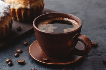 Coffee cup and muffins on the dark, textured background