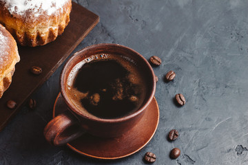 Coffee cup and muffins on the dark, textured background