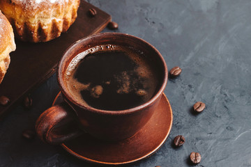 Coffee cup and muffins on the dark, textured background