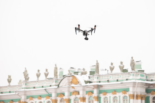 Quadcopter drone flies over the Palace square in St. Petersburg, The State Hermitage Museum on the background