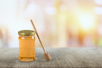 Honey and  wooden spoon  on background