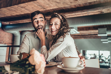 Romantic young couple spends time in restaurant.Girl feeding her boyfriend.Funny mood.