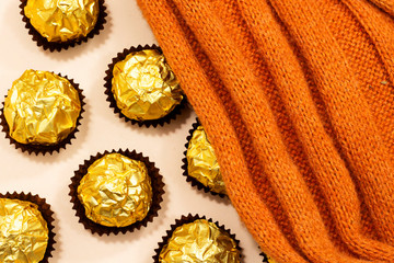 golden premium chocolate sweets under woolen winter scarf